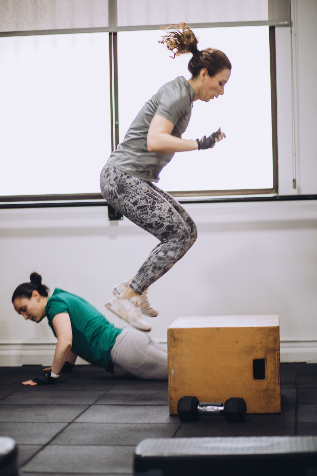 CB Movement Gym Dos mujeres entrenando en CB Movement Gym. Una salta el cajón mientras la otra hace flexiones.